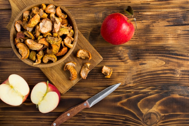 Manzanas secas en el recipiente sobre la mesa de madera