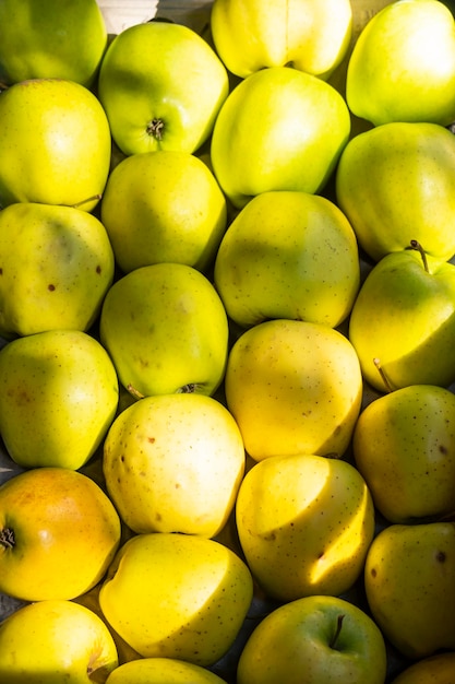 Manzanas verdes apiladas juntas en el stand de la granja Pila en ángulo vertical de enfoque selectivo de manzanas verdes