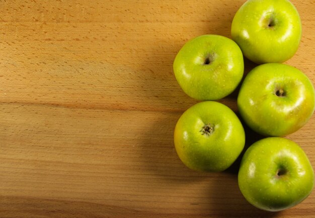 Manzanas verdes frescas en el fondo de madera