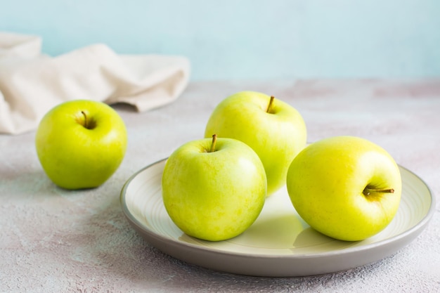 Manzanas verdes frescas en un plato sobre la mesa. Dieta de desintoxicación. Estilo de vida