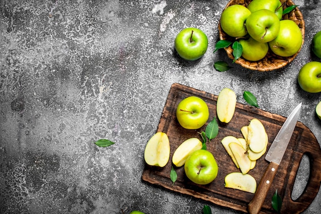 Manzanas verdes frescas en la tabla de cortar de mesa rústica.