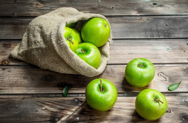 Manzanas verdes jugosas en un bolso viejo