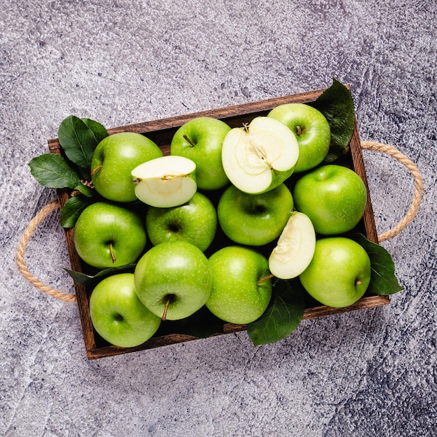 Manzanas verdes maduras en caja de madera