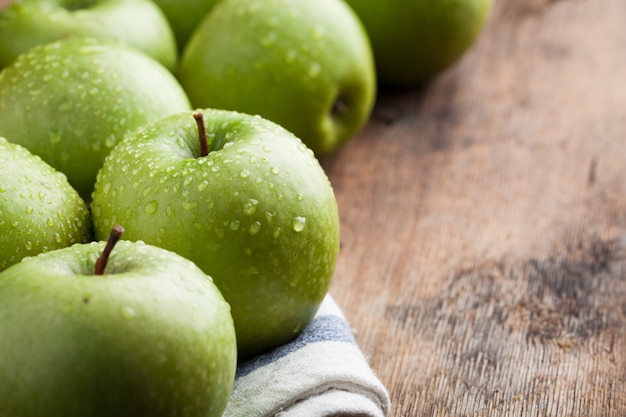 Manzanas verdes maduras en una mesa de madera.