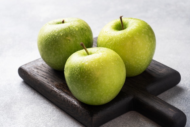 Manzanas verdes maduras sobre un hormigón gris