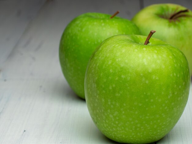 Manzanas verdes en mesa blanca