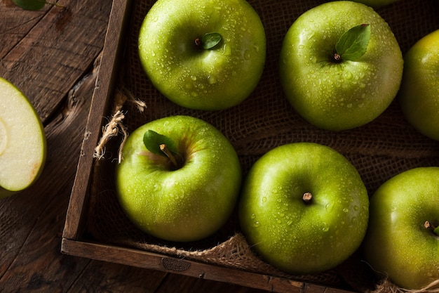 manzanas verdes en la mesa de madera