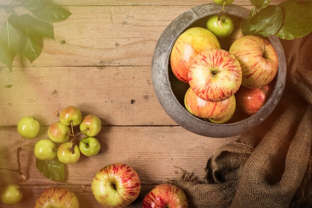 Manzanas verdes y rojas en mesa rústica