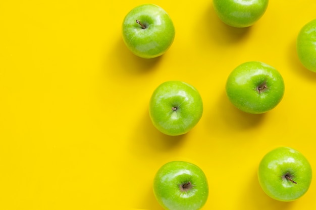 Manzanas verdes sobre fondo amarillo. Copia espacio