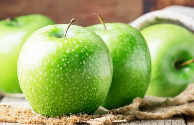 Manzanas verdes sobre fondo de madera vieja estilo rústico enfoque selectivo