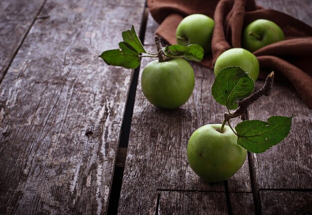 Manzanas verdes sobre fondo de madera