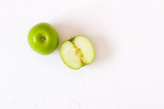 Manzanas verdes en la tabla blanca.