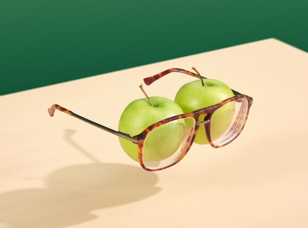 Manzanas verdes y vasos encima de la mesa Ojos de imitación Idea creativa visión saludable y estilo de vida