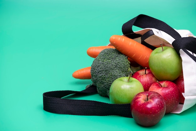 Manzanas y verduras en bolsa de tela.