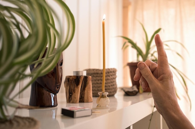 Mão acendendo vela de religião em casa