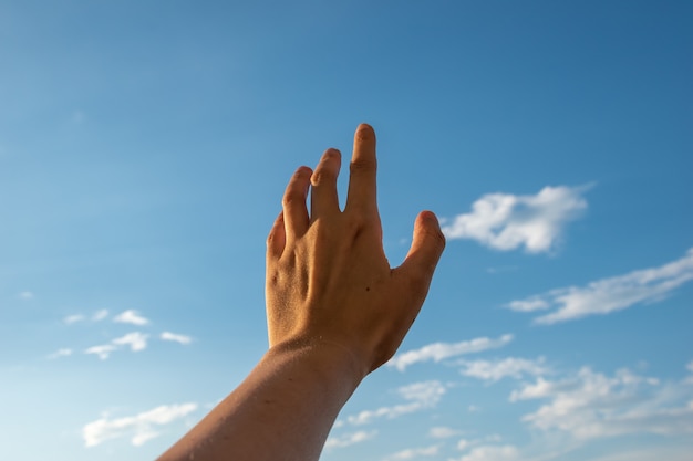 Mão alcançando o céu