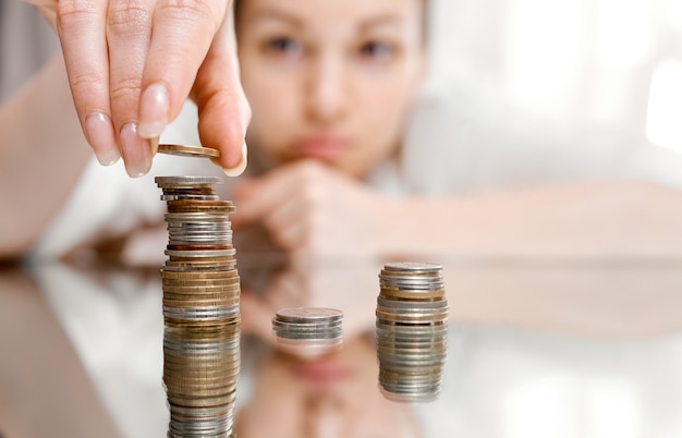 Mão, colocando a pilha de moedas de dinheiro crescendo, economizando dinheiro para o conceito de propósito. Foto de alta qualidade