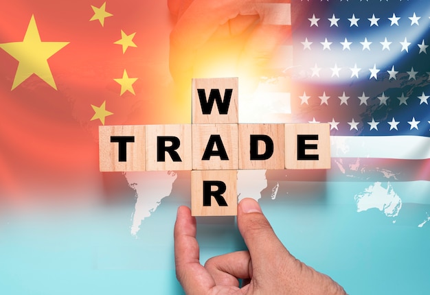 Mão colocando bloco de cubo de madeira para guerra comercial na bandeira da china e na bandeira dos eua. é o símbolo da guerra comercial de tarifas econômicas e da barreira fiscal entre os estados unidos da américa e a china.