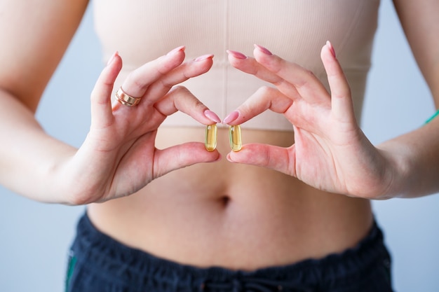 Mão com comprimidos. a mulher está tomando medicamentos para melhorar a imunidade. norma diária de vitaminas, preparações eficazes, farmácia moderna para a saúde.