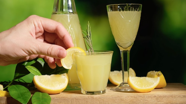 Mão com limoncello de bebida alcoólica de limão