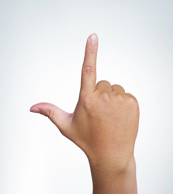 Mão com o dedo indicador no fundo branco com traçado de recorte