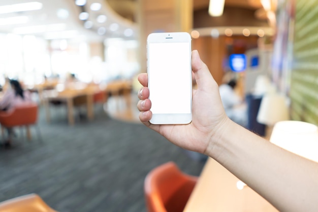 Mão com telefone inteligente do homem asiático no conceito de internet de tecnologia digital de conceito de sala de escritório