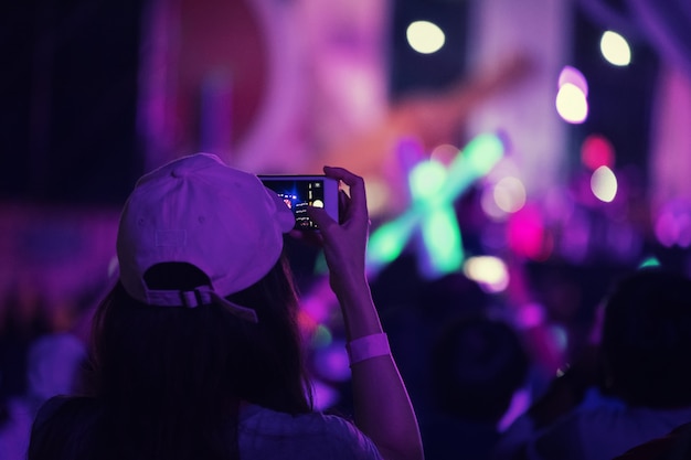Mão com um smartphone registra festival de música ao vivo