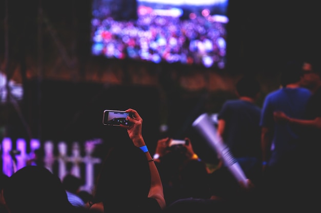 Mão com um smartphone registra festival de música ao vivo