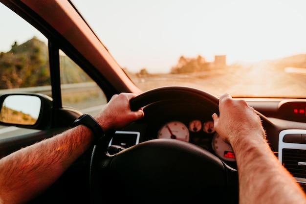 Mão cortada de homem a conduzir um carro.