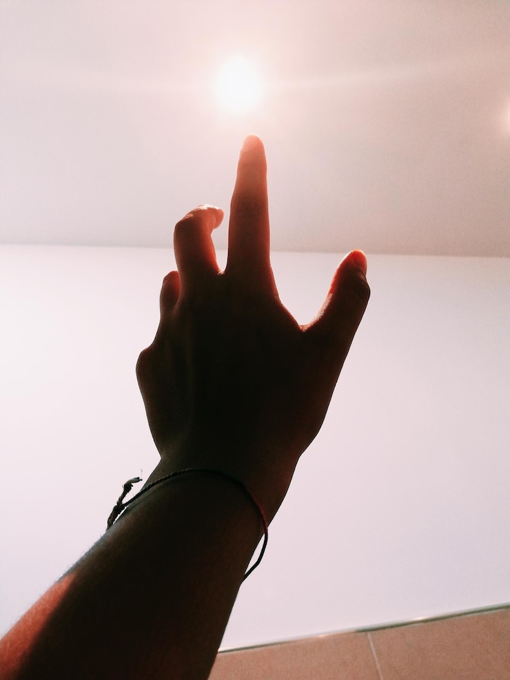 Foto mão cortada de mulher alcançando a luz iluminada