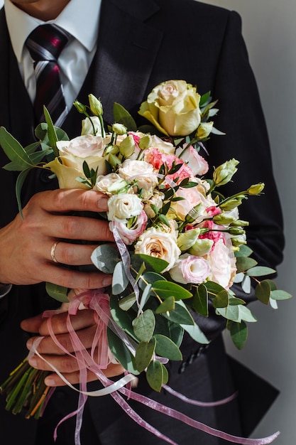 Mão cortada de mulher com homem segurando um buquê de rosas