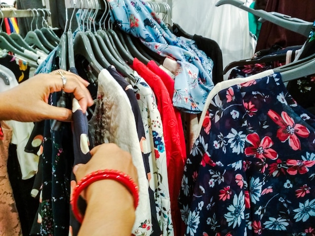 Mão cortada de mulher comprando roupas na loja