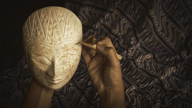 Foto mão cortada de mulher esculpindo máscara