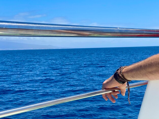 Foto mão cortada de mulher nadando no mar contra o céu