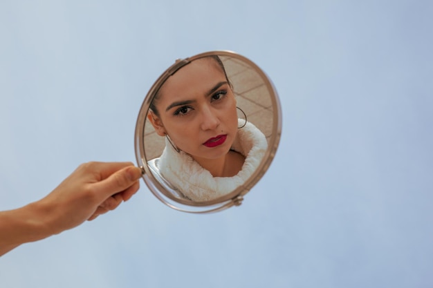 Foto mão cortada de mulher segurando espelho na cidade