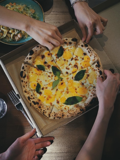 Foto mão cortada de mulher segurando pizza