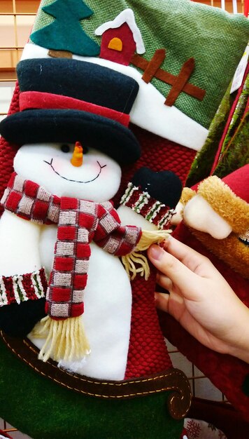 Foto mão cortada de mulher segurando um boneco de neve