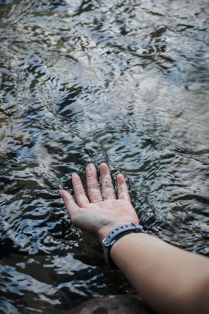 Mão cortada de mulher tocando água do rio