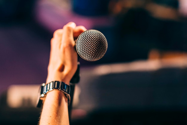 Mão cortada de músico segurando microfone