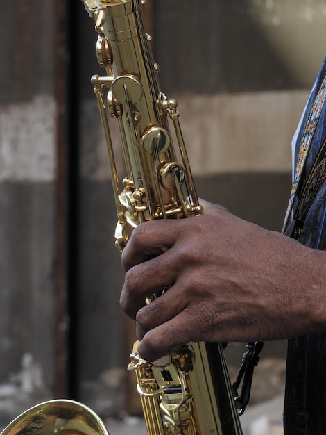 Mão cortada de músico tocando saxofone ao ar livre