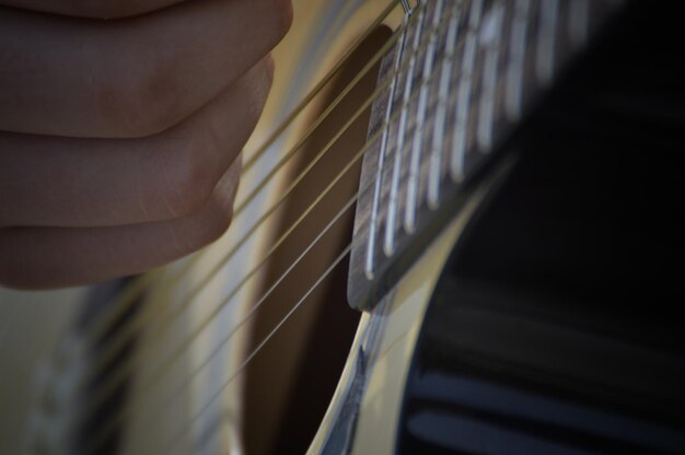 Foto mão cortada de pessoa tocando guitarra