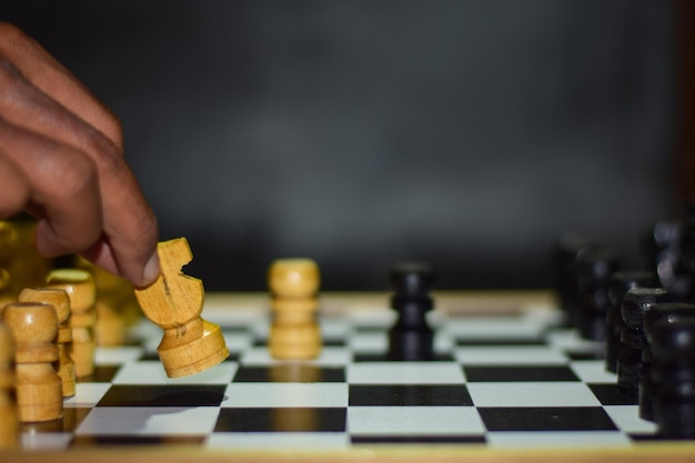 Foto mão cortada de um homem a jogar xadrez na mesa.