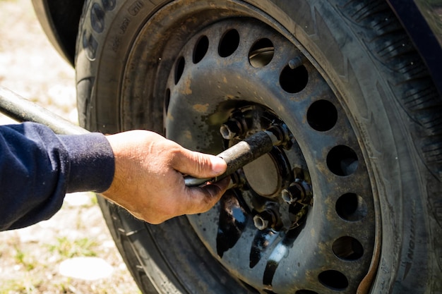 Foto mão cortada de um homem a reparar um carro.