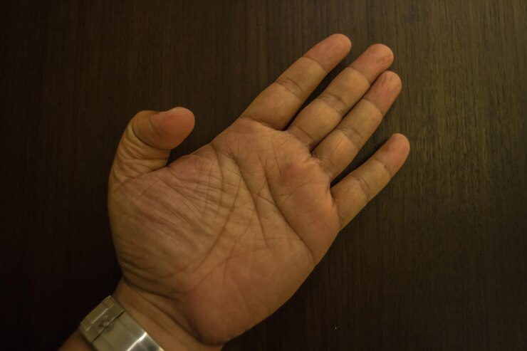 Foto mão cortada de um homem fazendo gestos em uma mesa de madeira