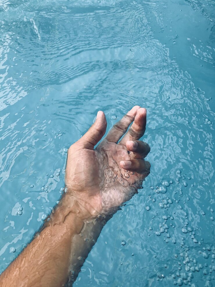 Foto mão cortada de um homem na piscina.