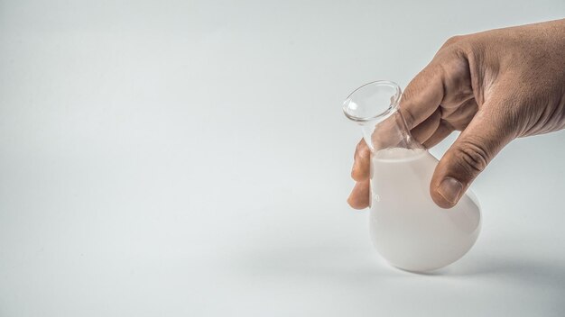 Foto mão cortada de um homem segurando um produto químico em um frasco sobre um fundo branco