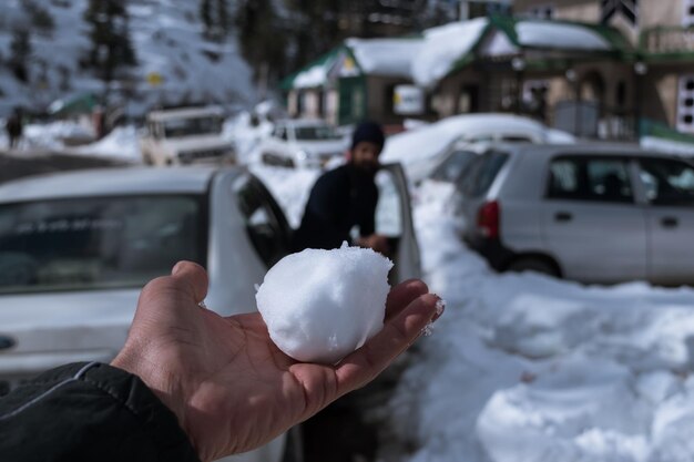 Foto mão cortada segurando a neve durante o inverno