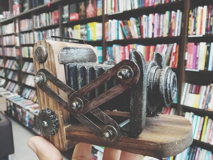 Foto mão cortada segurando lembranças por livros em prateleiras