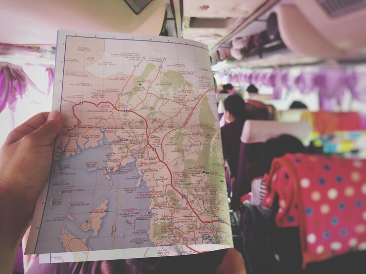 Foto mão cortada segurando mapa enquanto viaja em ônibus