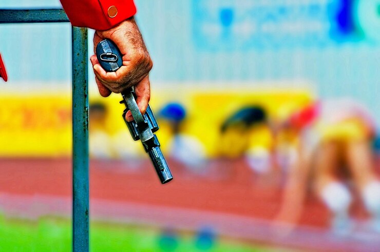 Foto mão cortada segurando uma arma durante a corrida